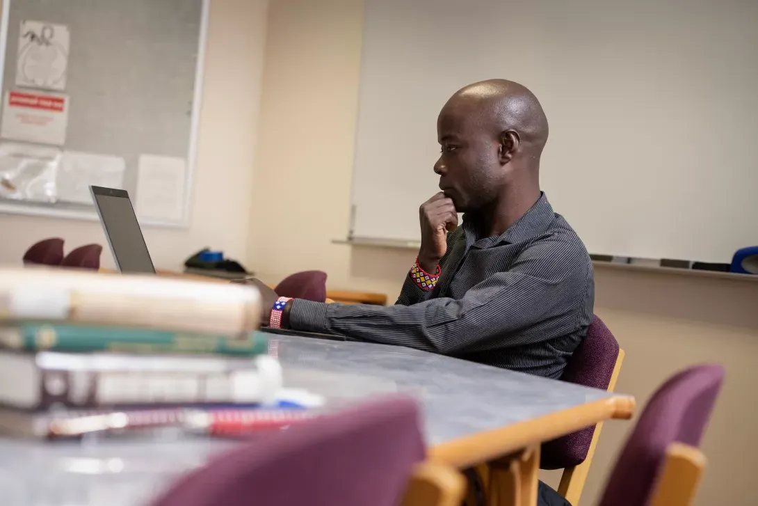 Student sitting at a table using a laptop computer